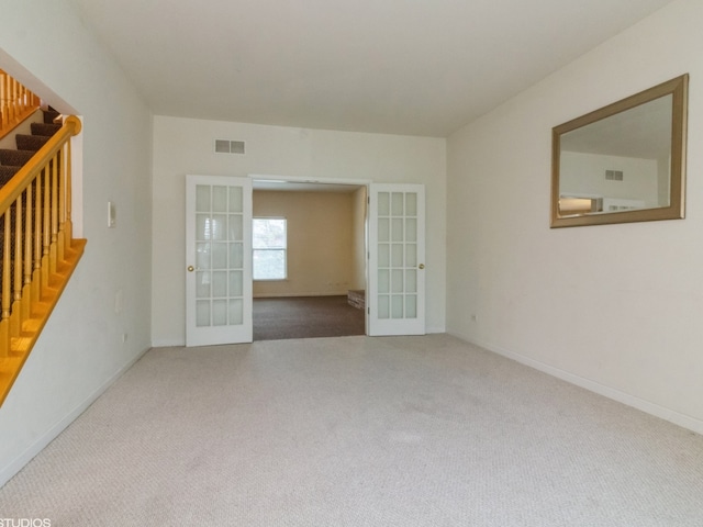 carpeted spare room featuring french doors