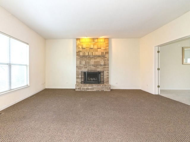 unfurnished living room with carpet floors and a brick fireplace