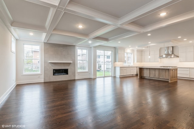 unfurnished living room featuring beamed ceiling, dark hardwood / wood-style flooring, and coffered ceiling