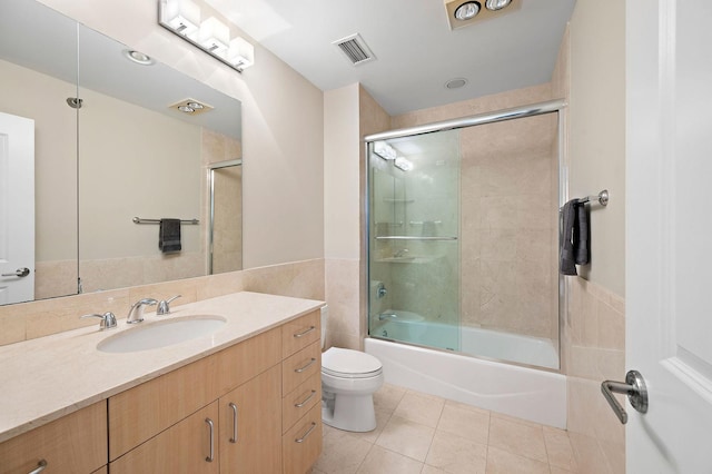 full bathroom with tile patterned flooring, vanity, shower / bath combination with glass door, and toilet