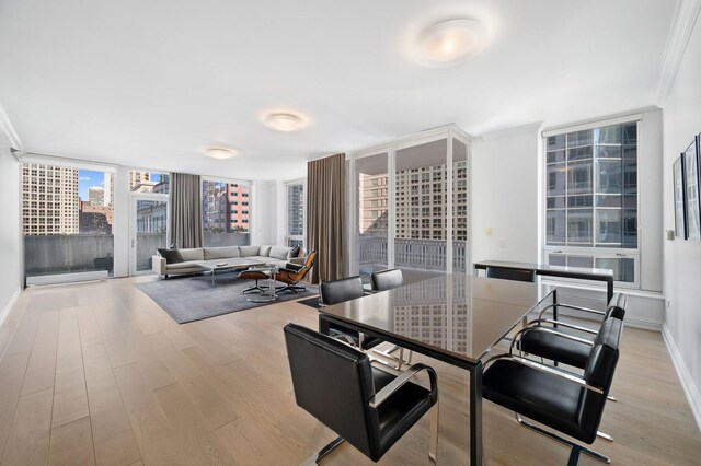 dining area with ornamental molding, floor to ceiling windows, and light wood-type flooring