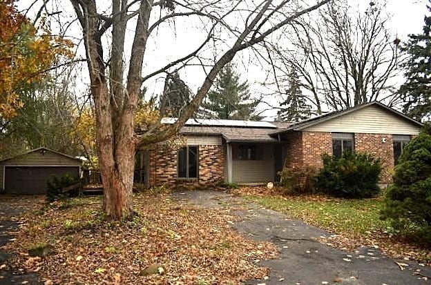 501 Grobe Rd, Sterling, IL 61081 - view of front of home featuring brick siding, solar panels, a detached garage, and an outbuilding