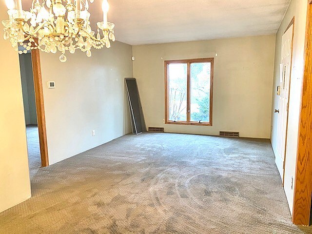 501 Grobe Rd, Sterling, IL 61081 - spare room with carpet flooring and a chandelier