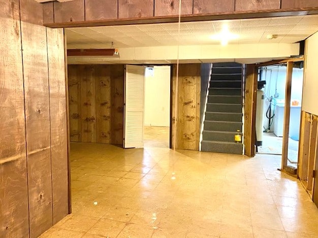 501 Grobe Rd, Sterling, IL 61081 - below grade area with stairway, wood walls, and tile patterned floors