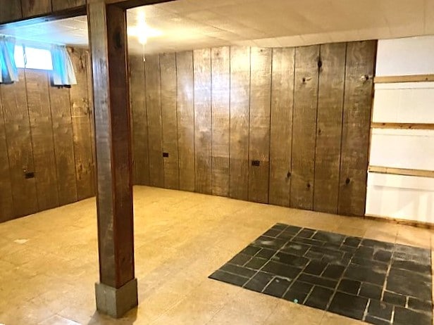 basement featuring wooden walls