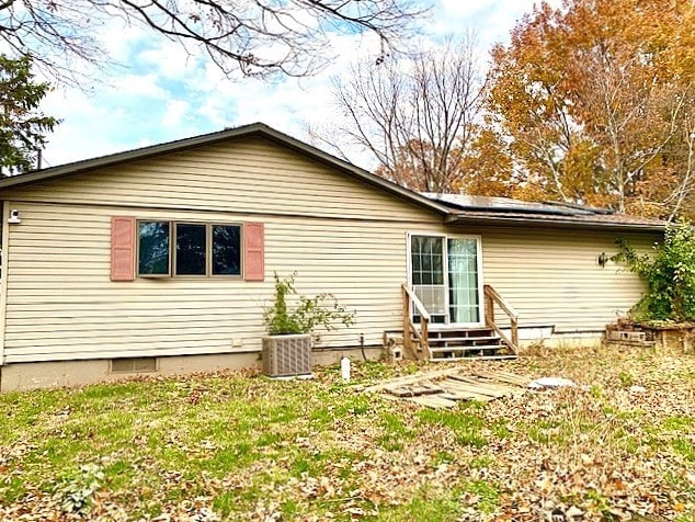 rear view of house featuring a yard