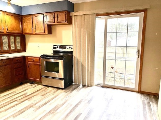 kitchen with stainless steel electric stove and light hardwood / wood-style floors