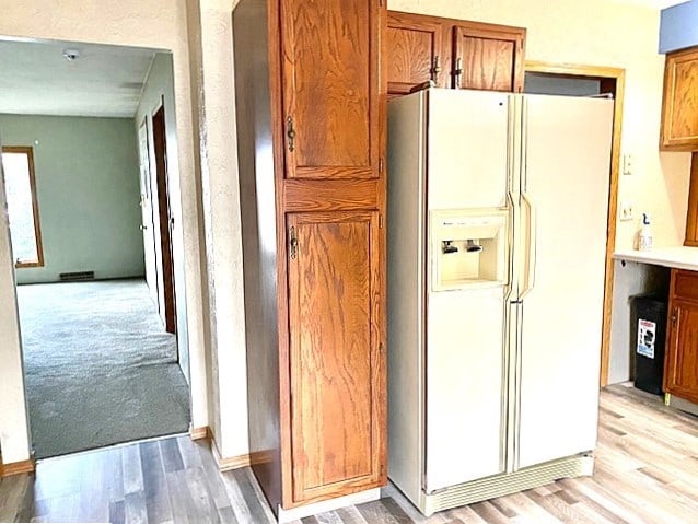 kitchen featuring white fridge with ice dispenser and light hardwood / wood-style flooring