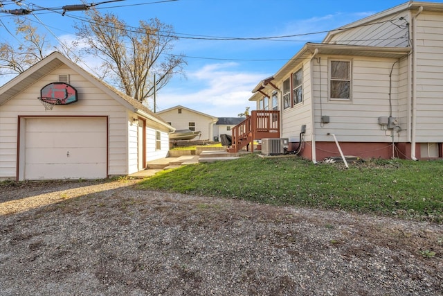 view of side of home with a lawn, central AC unit, and a garage