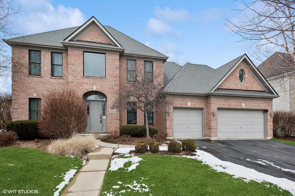 view of front of home with a front lawn and a garage