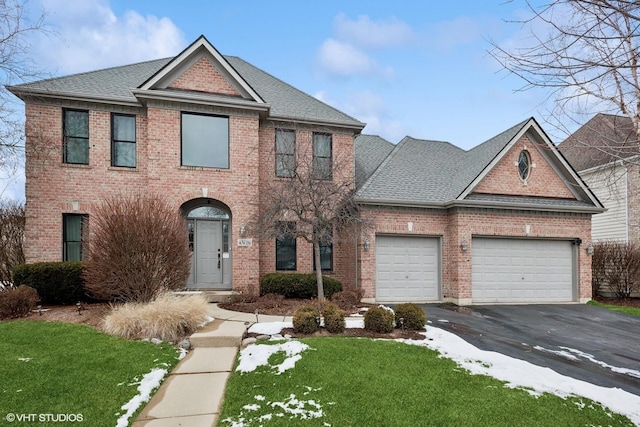 view of front of home with a front lawn and a garage