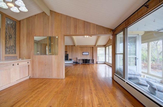 interior space with baseboard heating, lofted ceiling with beams, wood walls, a chandelier, and light hardwood / wood-style floors