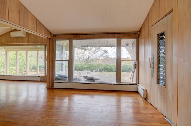 unfurnished sunroom featuring a wall mounted AC, baseboard heating, a wealth of natural light, and lofted ceiling