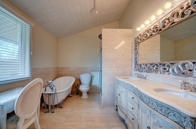 bathroom with a washtub, toilet, tile walls, and vaulted ceiling