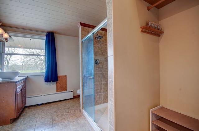 bathroom with vanity, toilet, a shower with shower door, and a baseboard radiator