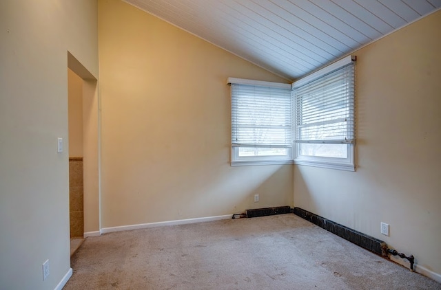 empty room featuring light colored carpet, lofted ceiling, and wooden ceiling