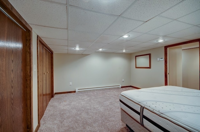 bedroom featuring carpet floors, a baseboard radiator, and a drop ceiling