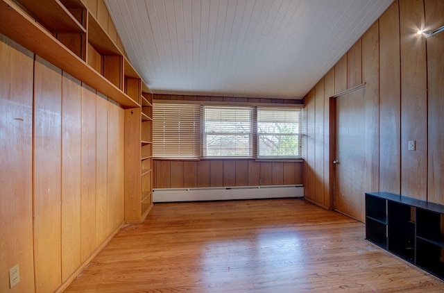 interior space featuring light hardwood / wood-style floors, baseboard heating, and wooden walls