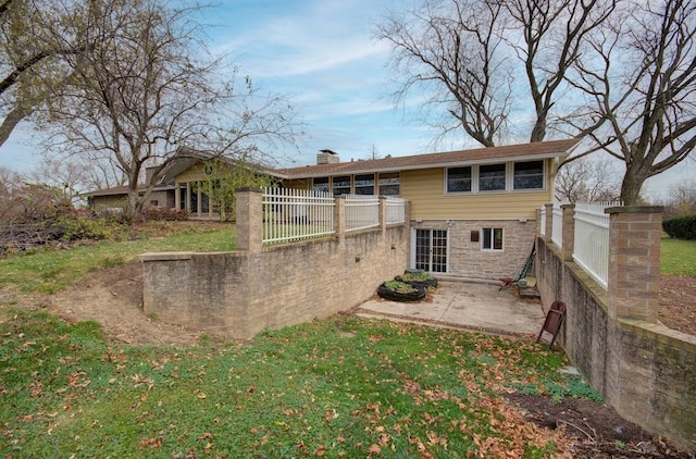 back of house with a yard and a patio