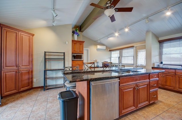 kitchen featuring appliances with stainless steel finishes, rail lighting, a kitchen island with sink, and sink