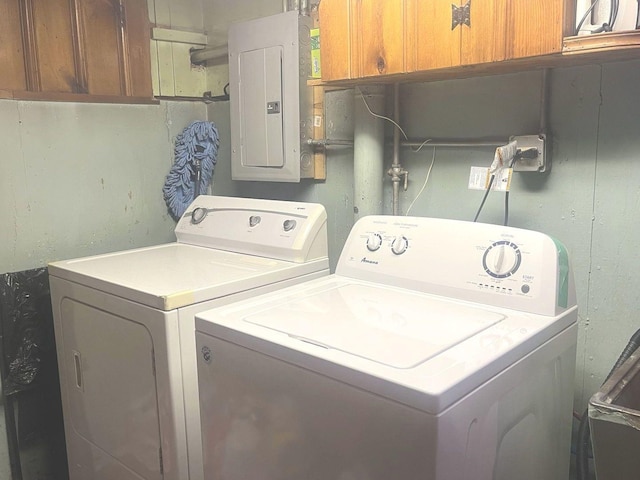 washroom with washer and dryer, electric panel, and cabinets