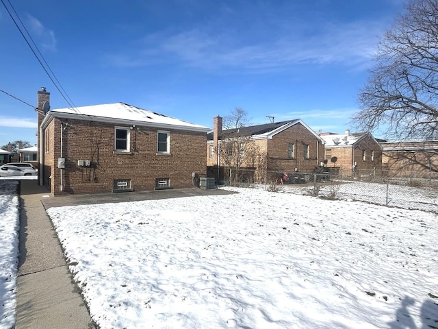 view of snow covered rear of property