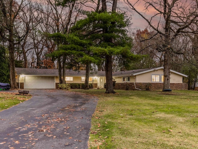 ranch-style home featuring a yard and a garage