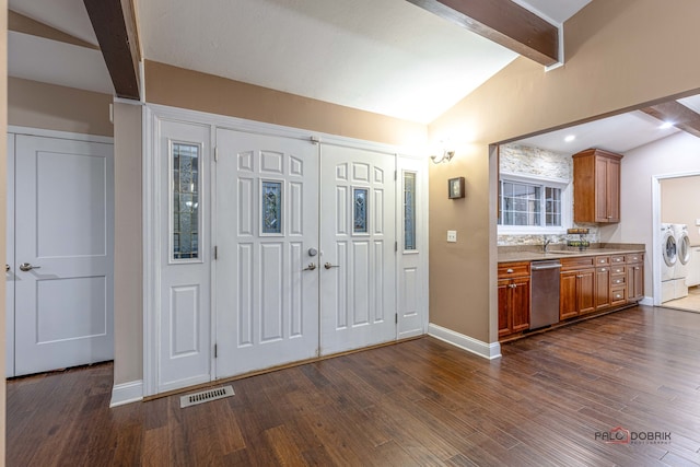 entryway featuring dark hardwood / wood-style flooring, lofted ceiling with beams, and separate washer and dryer