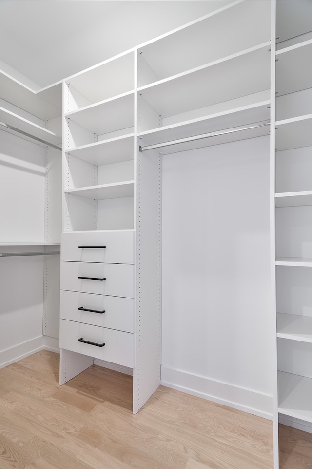 walk in closet with light hardwood / wood-style flooring