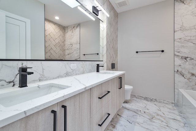 bathroom featuring vanity, a bathtub, and toilet