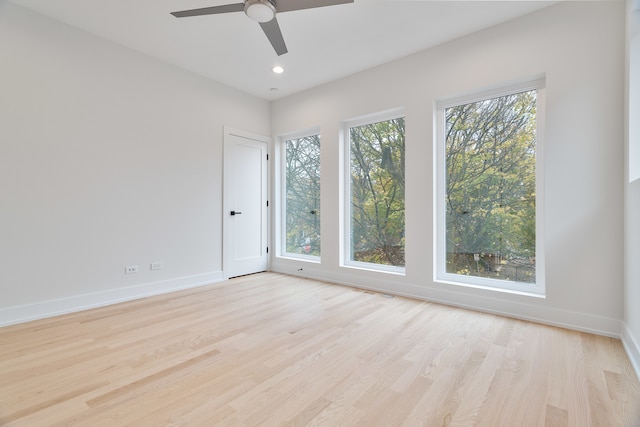 spare room featuring a wealth of natural light, ceiling fan, and light hardwood / wood-style floors