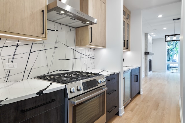 kitchen with pendant lighting, high end stainless steel range, light hardwood / wood-style flooring, light stone countertops, and range hood