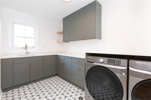 washroom featuring cabinets, separate washer and dryer, sink, and light tile patterned floors