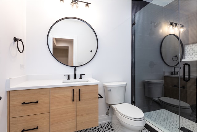 bathroom featuring tile patterned flooring, vanity, toilet, and a shower with door