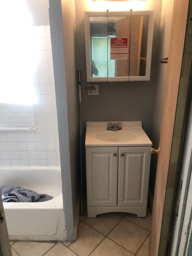 bathroom featuring vanity, a tub to relax in, and tile patterned floors