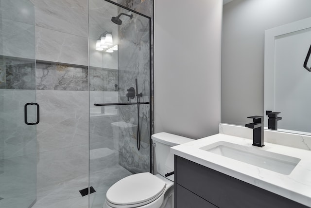 bathroom featuring a shower with door, vanity, and toilet