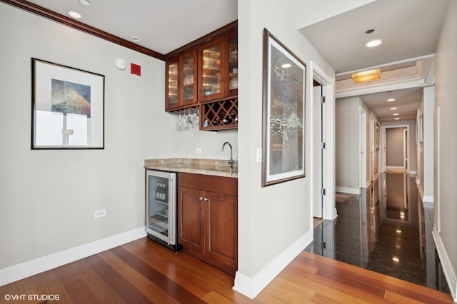 bar featuring light stone counters, crown molding, sink, dark hardwood / wood-style floors, and wine cooler