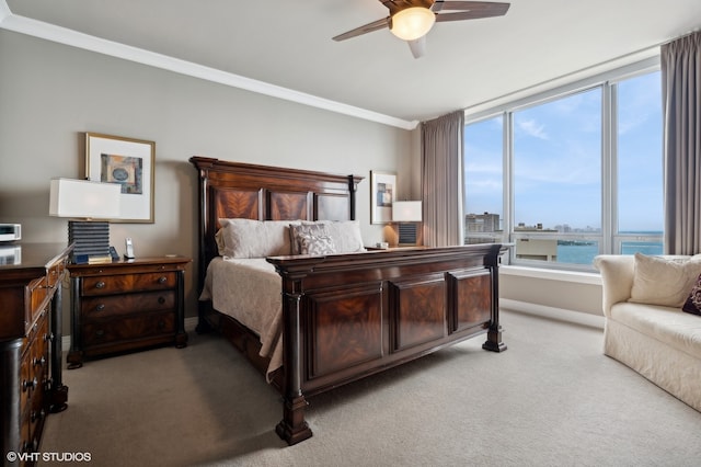 carpeted bedroom featuring ceiling fan, crown molding, and a water view