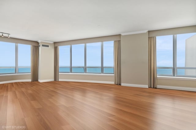 living room with light wood-type flooring, ornamental molding, and bar