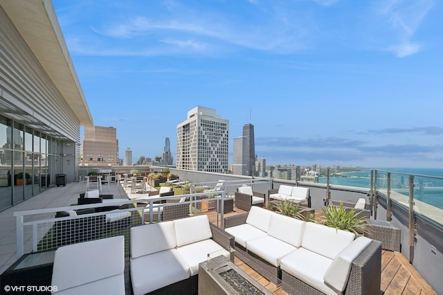 view of patio with an outdoor living space, a water view, and a balcony