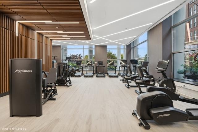 workout area with floor to ceiling windows and light wood-type flooring