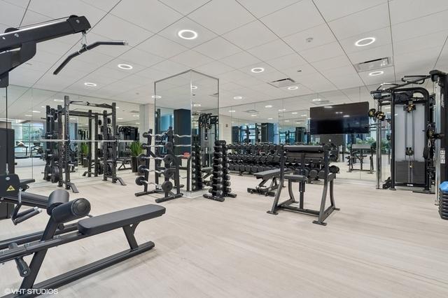 gym featuring hardwood / wood-style flooring and a drop ceiling