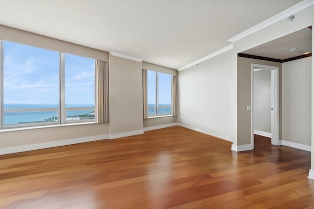 dining room with a healthy amount of sunlight, a water view, and light hardwood / wood-style flooring