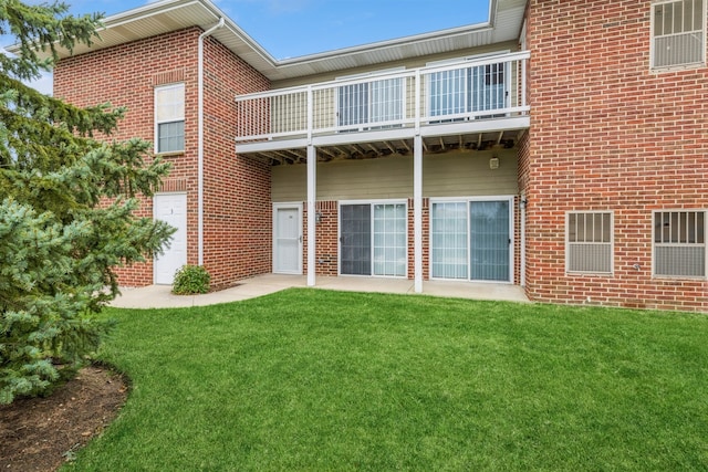 rear view of house with a balcony and a yard