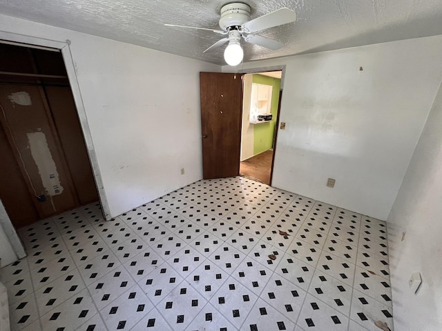 bedroom featuring ceiling fan, a closet, and a textured ceiling