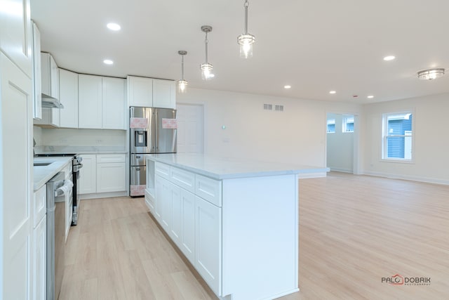 kitchen featuring a kitchen island, white cabinetry, hanging light fixtures, and appliances with stainless steel finishes