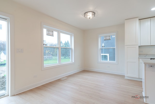 unfurnished dining area with light hardwood / wood-style flooring and a healthy amount of sunlight