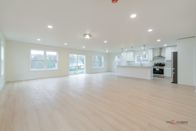 unfurnished living room with light wood-type flooring and sink