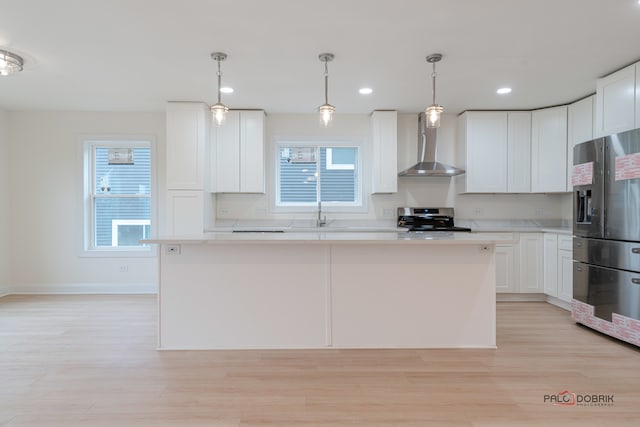 kitchen featuring white cabinetry, plenty of natural light, wall chimney exhaust hood, and stainless steel appliances