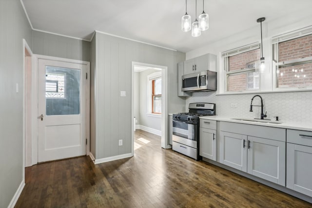 kitchen with sink, decorative backsplash, hanging light fixtures, appliances with stainless steel finishes, and gray cabinets